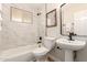 Stylish bathroom featuring a shower-tub combo with marble tile and modern fixtures at 2408 W Flower St, Phoenix, AZ 85015
