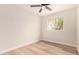 Bright bedroom with wood floors, a ceiling fan, and a view to greenery outside the window at 2408 W Flower St, Phoenix, AZ 85015