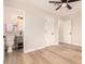 Spacious bedroom with wood-look floors, ceiling fan, and ensuite bathroom access offers comfort and convenience at 2408 W Flower St, Phoenix, AZ 85015