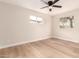 Neutral bedroom features wood-look flooring, a ceiling fan, and dual windows for natural light at 2408 W Flower St, Phoenix, AZ 85015
