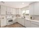 Well-lit kitchen boasts ample countertop space, clean white cabinetry, and modern appliances at 2408 W Flower St, Phoenix, AZ 85015