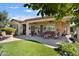 This backyard has a built-in grill, patio, comfortable seating, and a well-manicured lawn at 27280 N Makena Pl, Peoria, AZ 85383