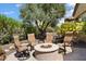 Outdoor seating area with a fire pit, lush landscaping, and paver patio at 27280 N Makena Pl, Peoria, AZ 85383