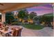 Outdoor living space with landscaped backyard, synthetic grass, rock detail and paver patio at 27280 N Makena Pl, Peoria, AZ 85383