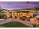 Inviting covered patio with outdoor furniture, BBQ grill and lush backyard landscaping at 27280 N Makena Pl, Peoria, AZ 85383