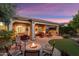 Covered patio with outdoor furniture, BBQ grill, and landscaped backyard with fire pit at 27280 N Makena Pl, Peoria, AZ 85383