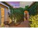 Enclosed outdoor patio featuring a stone walkway, manicured greenery, and an ivy-covered archway at 27280 N Makena Pl, Peoria, AZ 85383