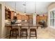 Gourmet kitchen boasts granite counters, wooden cabinetry, pendant lights, and a breakfast bar with seating at 27280 N Makena Pl, Peoria, AZ 85383