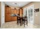 Eat-in kitchen area features wooden cabinets, tiled floors, and a cozy breakfast table with shuttered doors at 27280 N Makena Pl, Peoria, AZ 85383