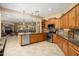 Spacious kitchen features wooden cabinetry, stainless steel appliances, granite counters, and an eat-in island overlooking the living room at 27280 N Makena Pl, Peoria, AZ 85383