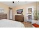 Large primary suite with wood floors, natural light, ceiling fan, furniture, and a door to the outside at 27280 N Makena Pl, Peoria, AZ 85383