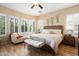 Bright main bedroom suite with a seating area by the window, wood floors, a ceiling fan, and shuttered windows at 27280 N Makena Pl, Peoria, AZ 85383