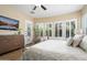 Inviting main bedroom suite features an adjacent seating area, hardwood floors, shuttered windows, and ceiling fan at 27280 N Makena Pl, Peoria, AZ 85383