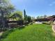 Lush backyard with mature trees, grassy lawn, a pool, and a hot tub at 2833 E Emile Zola Ave, Phoenix, AZ 85032