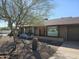 Charming single-story home featuring desert landscaping and a warm, inviting entrance with wood door at 2833 E Emile Zola Ave, Phoenix, AZ 85032