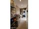 Functional laundry room with modern appliances, ample storage shelving, and counter space for convenience at 2833 E Emile Zola Ave, Phoenix, AZ 85032