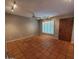 Spacious living room with terracotta floors, a ceiling fan, track lighting and shuttered windows at 2833 E Emile Zola Ave, Phoenix, AZ 85032
