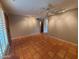 Spacious living room with terracotta floors, fan, and track lighting at 2833 E Emile Zola Ave, Phoenix, AZ 85032