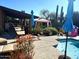 Tranquil outdoor pool area featuring comfortable seating, blue sun umbrellas, a gazebo and desert landscaping at 2833 E Emile Zola Ave, Phoenix, AZ 85032