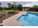 Inviting pool with clean blue water and a built-in bar area, surrounded by mature landscaping at 2833 E Emile Zola Ave, Phoenix, AZ 85032
