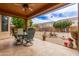 Covered back patio with a dining set overlooking the backyard landscape at 3023 E Silversmith Trl, San Tan Valley, AZ 85143