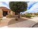 Landscaped front yard featuring desert-style gravel, mature trees, and view of neighborhood park at 3023 E Silversmith Trl, San Tan Valley, AZ 85143