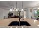 Open kitchen with large granite island, double sink, and view of the living area at 3023 E Silversmith Trl, San Tan Valley, AZ 85143