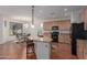 Open kitchen with an island, light wood cabinets, black appliances, and tile flooring throughout at 3023 E Silversmith Trl, San Tan Valley, AZ 85143