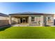 A backyard view highlighting an artificial grass lawn, patio, and well-maintained exterior at 30323 W Sheila Ln, Buckeye, AZ 85396