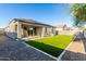 A well-maintained backyard featuring synthetic grass, gravel, block wall, and a covered patio at 30323 W Sheila Ln, Buckeye, AZ 85396