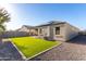 Charming backyard featuring artificial lawn, rock bed, privacy wall, and solar panels at 30323 W Sheila Ln, Buckeye, AZ 85396