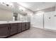 Bathroom featuring double vanity, large mirror, and glass enclosed shower at 30323 W Sheila Ln, Buckeye, AZ 85396