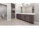 Spacious bathroom with double vanity, a large mirror, and neutral colored tiling at 30323 W Sheila Ln, Buckeye, AZ 85396