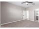 Neutral bedroom with a ceiling fan, carpet, an open door to the bathroom, and neutral walls at 30323 W Sheila Ln, Buckeye, AZ 85396