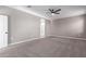 Spacious carpeted bedroom with ceiling fan; bathroom entrance visible at 30323 W Sheila Ln, Buckeye, AZ 85396