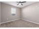 An unfurnished bedroom with neutral walls and carpet, ceiling fan, and a window at 30323 W Sheila Ln, Buckeye, AZ 85396