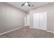 A neutral carpeted bedroom with a ceiling fan and closet with sliding doors at 30323 W Sheila Ln, Buckeye, AZ 85396