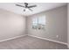 A neutral bedroom with a ceiling fan, a window with blinds, carpet, and base trim at 30323 W Sheila Ln, Buckeye, AZ 85396