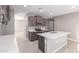 An open-concept kitchen has stainless steel appliances, a kitchen island, and stone countertops at 30323 W Sheila Ln, Buckeye, AZ 85396