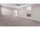 Large primary bedroom with neutral carpet, paint, ceiling fan, and en suite bathroom entrance at 30323 W Sheila Ln, Buckeye, AZ 85396