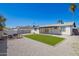 The beautiful backyard features low maintenance gravel, grass and a white colored house at 3437 E Acoma Dr, Phoenix, AZ 85032