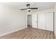 Spacious bedroom with wood-look floors, ceiling fan, and double door closet at 3437 E Acoma Dr, Phoenix, AZ 85032