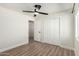 Bright bedroom with wood-look floors, ceiling fan, and closet at 3437 E Acoma Dr, Phoenix, AZ 85032