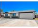 The home's exterior is designed with desert landscaping, a two-car garage, and an inviting yellow front door at 3437 E Acoma Dr, Phoenix, AZ 85032