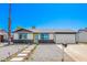 Charming single-story home features a yellow front door, a two-car garage, and low maintenance desert landscaping at 3437 E Acoma Dr, Phoenix, AZ 85032