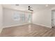 Bright living room with wood-look floors, fan, and a back door providing backyard access and natural light at 3437 E Acoma Dr, Phoenix, AZ 85032