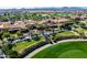 Stunning aerial view of the community clubhouse, lush golf course and palm trees under a clear blue sky at 36053 N Stoneware Dr, Queen Creek, AZ 85140