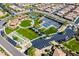 Aerial view of community amenities including pool, tennis courts, a lawn, and well-manicured landscaping at 36053 N Stoneware Dr, Queen Creek, AZ 85140