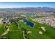 Expansive aerial view showcasing the community's lush green golf course, lakes, and beautiful homes under a clear blue sky at 36053 N Stoneware Dr, Queen Creek, AZ 85140