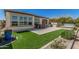 Spacious backyard with artificial turf, an outdoor dining area, and a built-in hot tub at 36053 N Stoneware Dr, Queen Creek, AZ 85140
